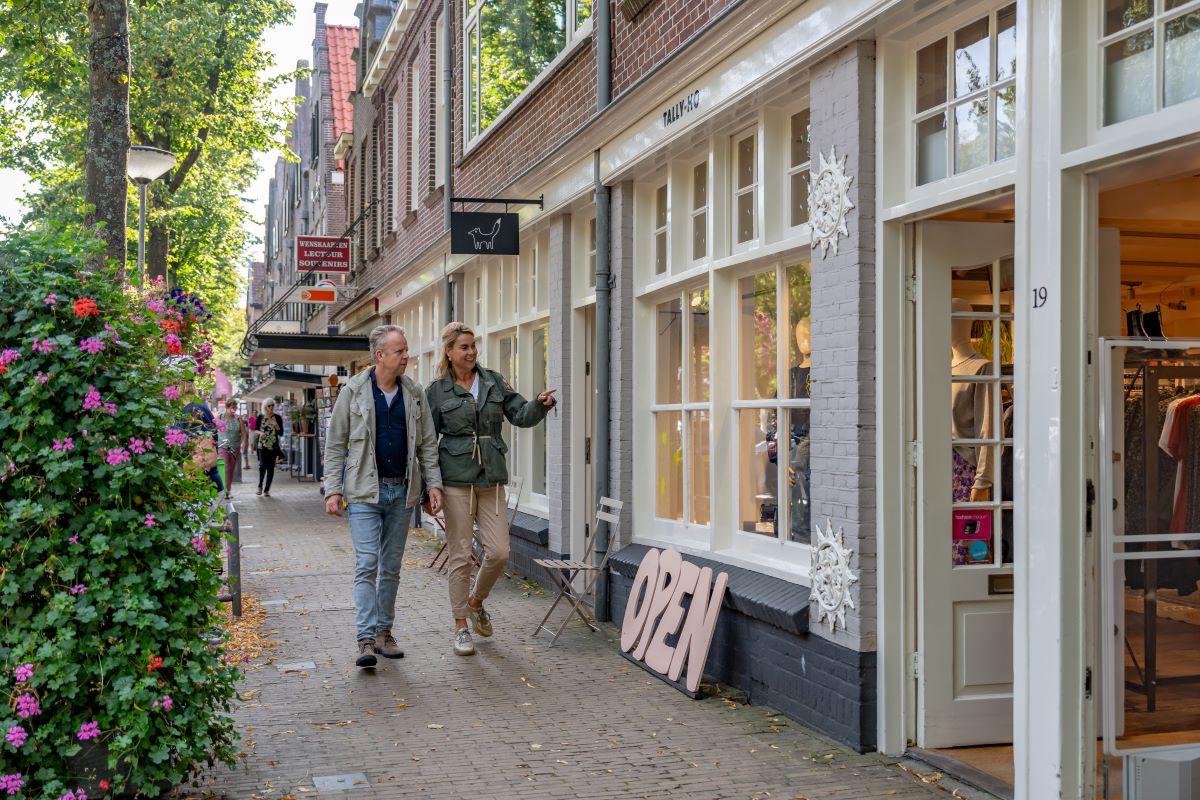 twee mensen wandelend door de winkelstraat van Bergen